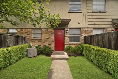 the front yard of a house with a red door