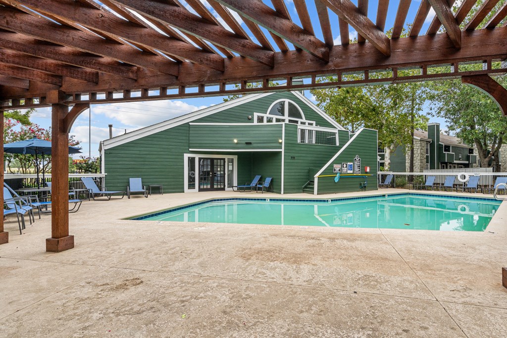 a green building with a pool in front of it