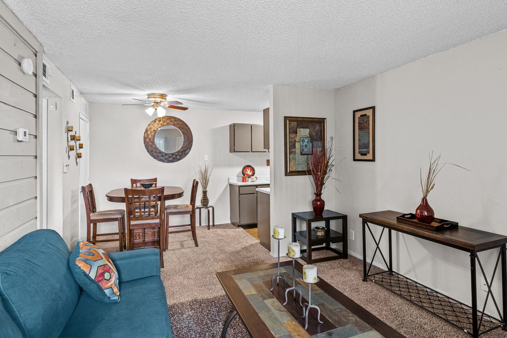 a living room with a couch a table and a ceiling fan