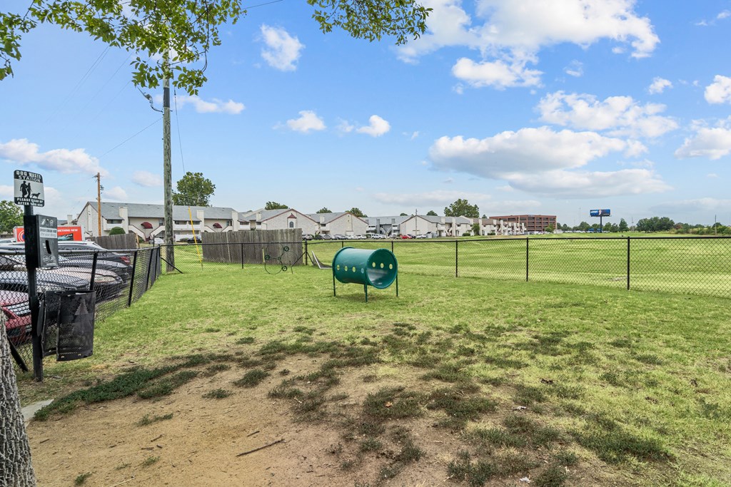 a fenced in dog park with agility courses and agility ropes