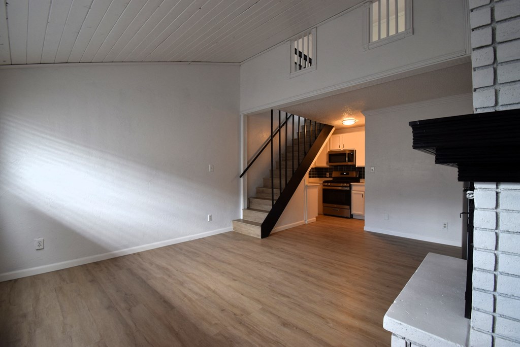 a view of a living room with wood floors and a staircase
