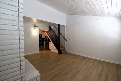 a view of a living room with wood floors and a staircase