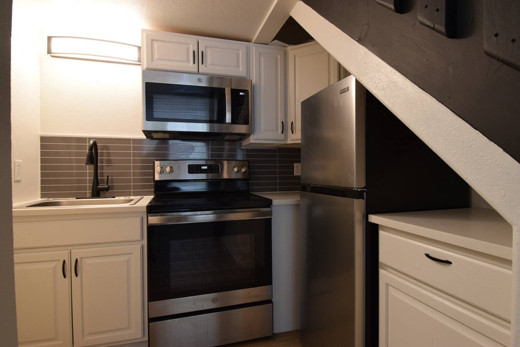 a kitchen with stainless steel appliances and white cabinets