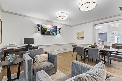 a living room with couches and chairs and a table and a tv