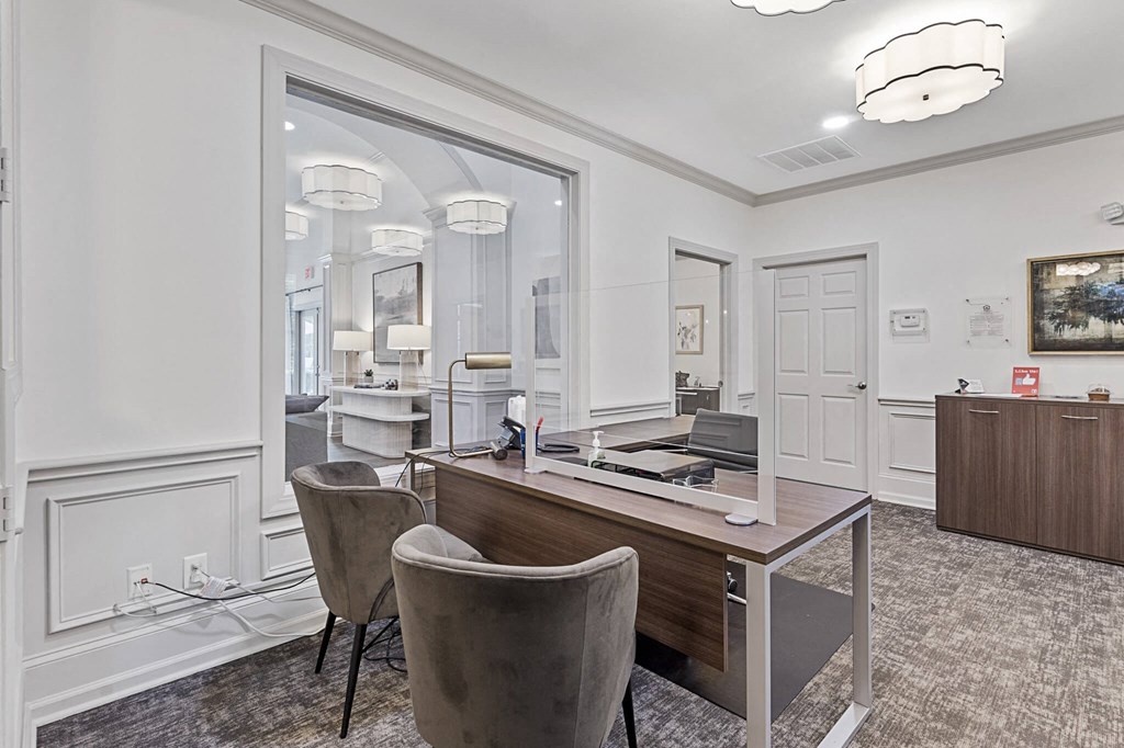 a conference room with a desk and chairs and a mirror