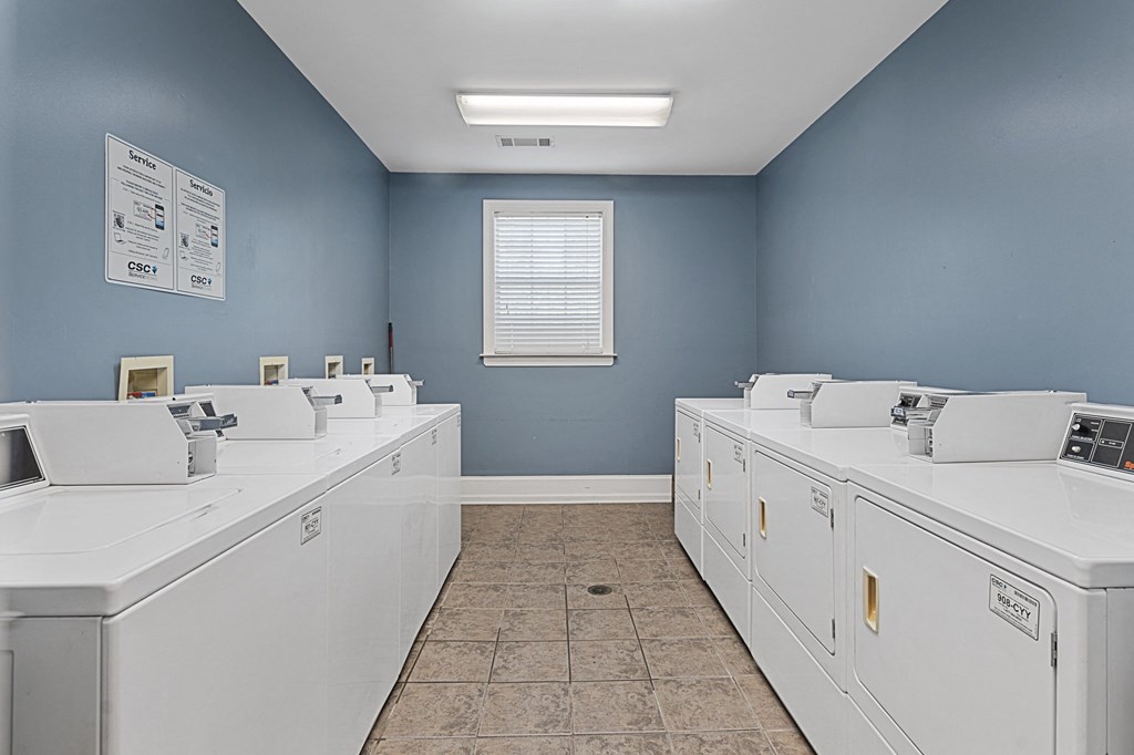 a row of washing machines in a laundry room with blue walls