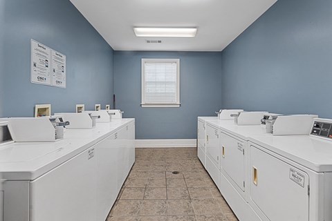 a row of washing machines in a laundry room with blue walls