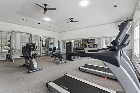 a gym with treadmills and other exercise equipment and windows