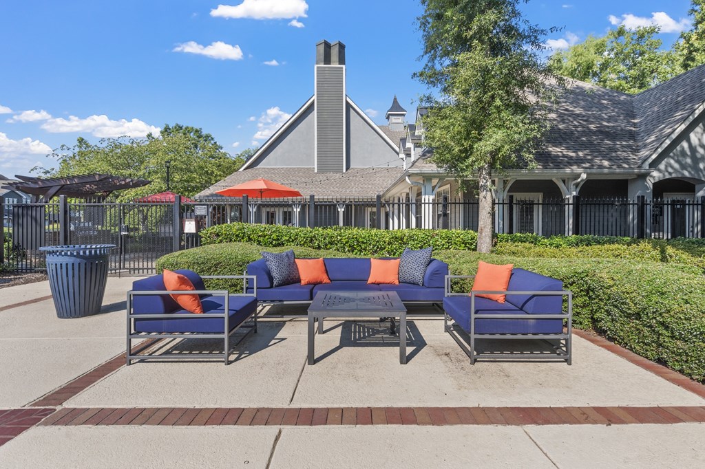 a patio with couches and a table in front of a house