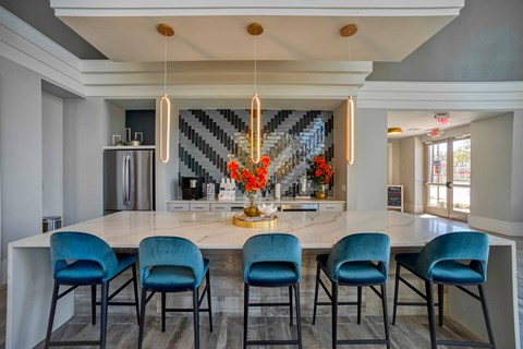 a large kitchen with a marble counter top and blue chairs
