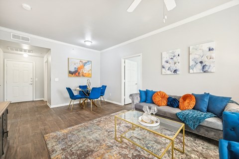 a living room with blue couches and a glass coffee table