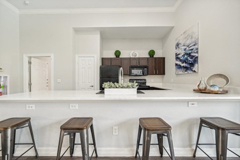 a kitchen with bar stools and a counter top with stools