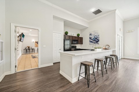 a kitchen with a white counter top and bar stools