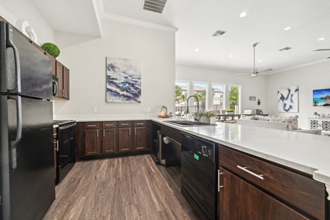 a large kitchen with wooden cabinets and a white counter top
