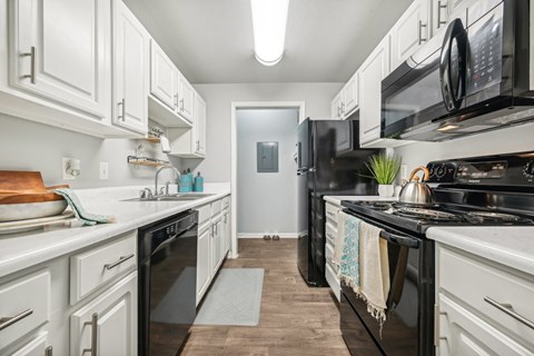a kitchen with white cabinetry and black appliances
