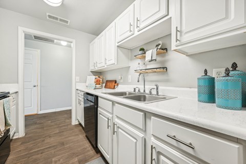 a kitchen with white cabinets and a sink    and a door to a