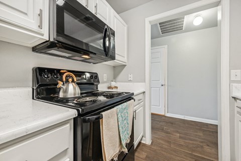 the kitchen of a home with a stove and a microwave