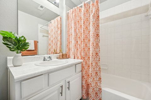 a bathroom with a sink and a tub and a shower curtain