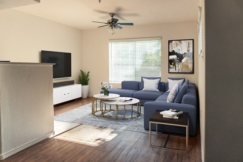 a living room with a blue couch and a ceiling fan