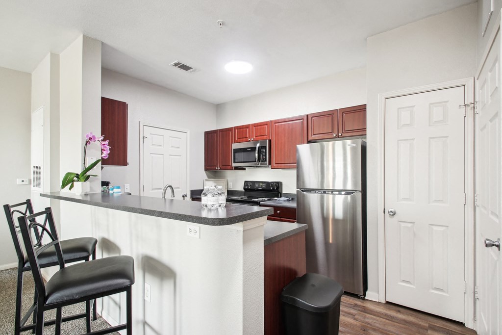 a kitchen with a island and a stainless steel refrigerator