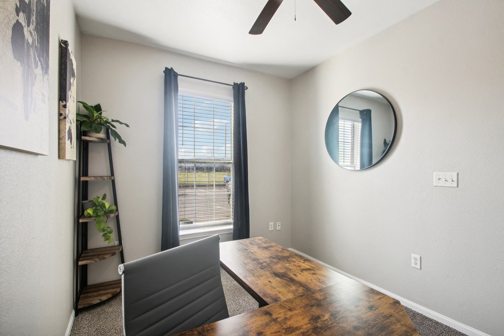 a dining room with a large window and a desk with a laptop