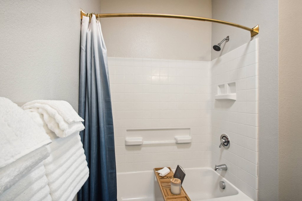 a bathroom with a shower and a sink and a towel rack