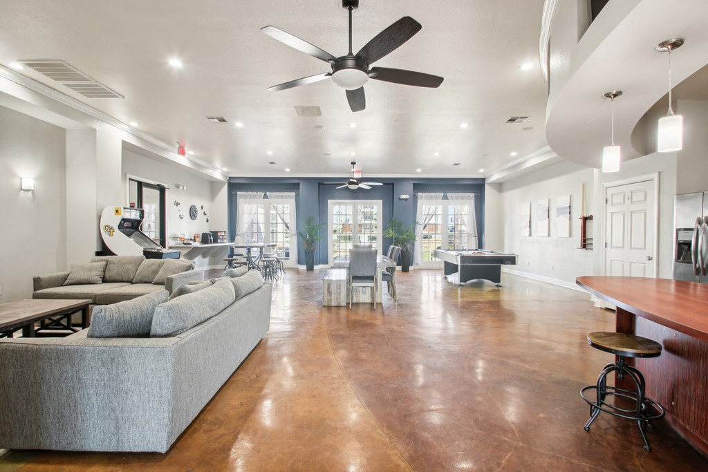 a living room with couches and a ceiling fan