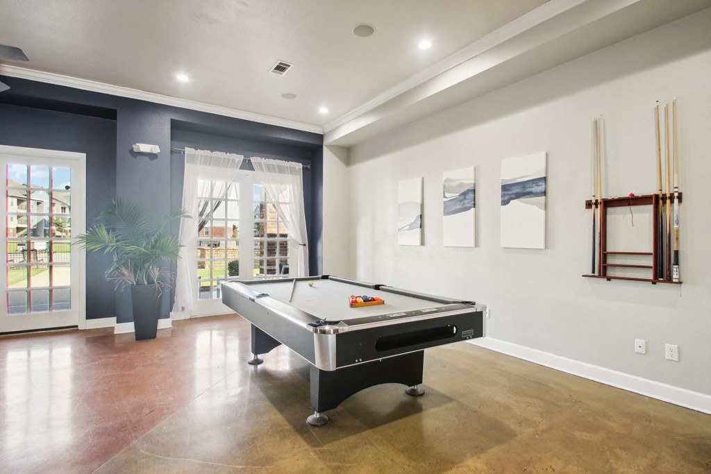 a game room with a pool table and a window