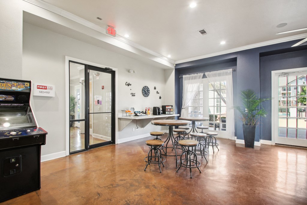 a dining room with tables and stools in front of a window and a counter