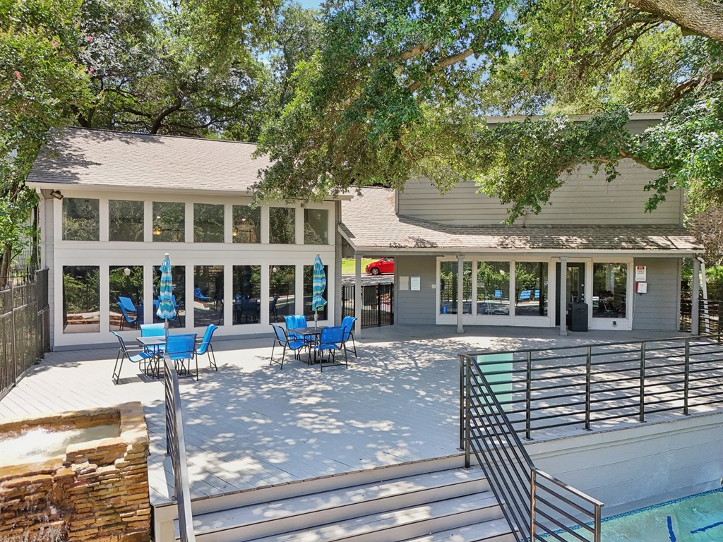 a patio with chairs and a pool in front of a house