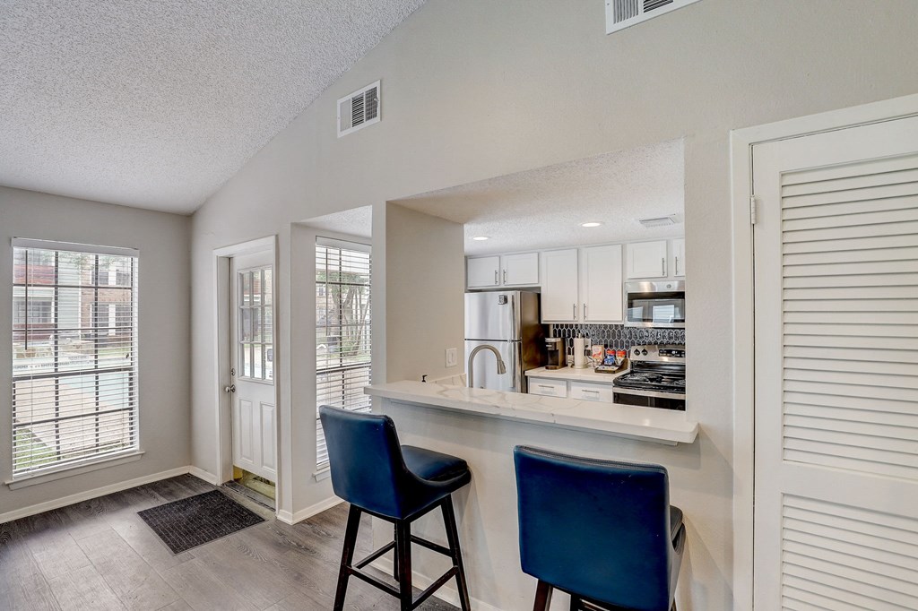 the preserve at ballantyne commons apartment kitchen and bar with blue chairs