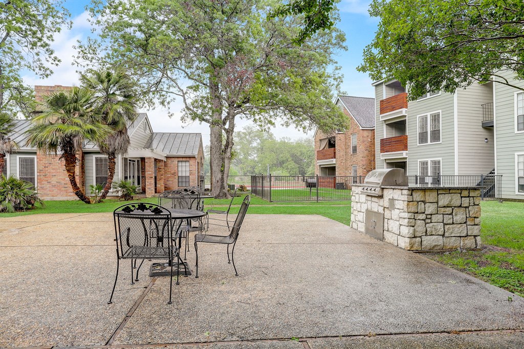 a patio with a table and chairs in front of a house