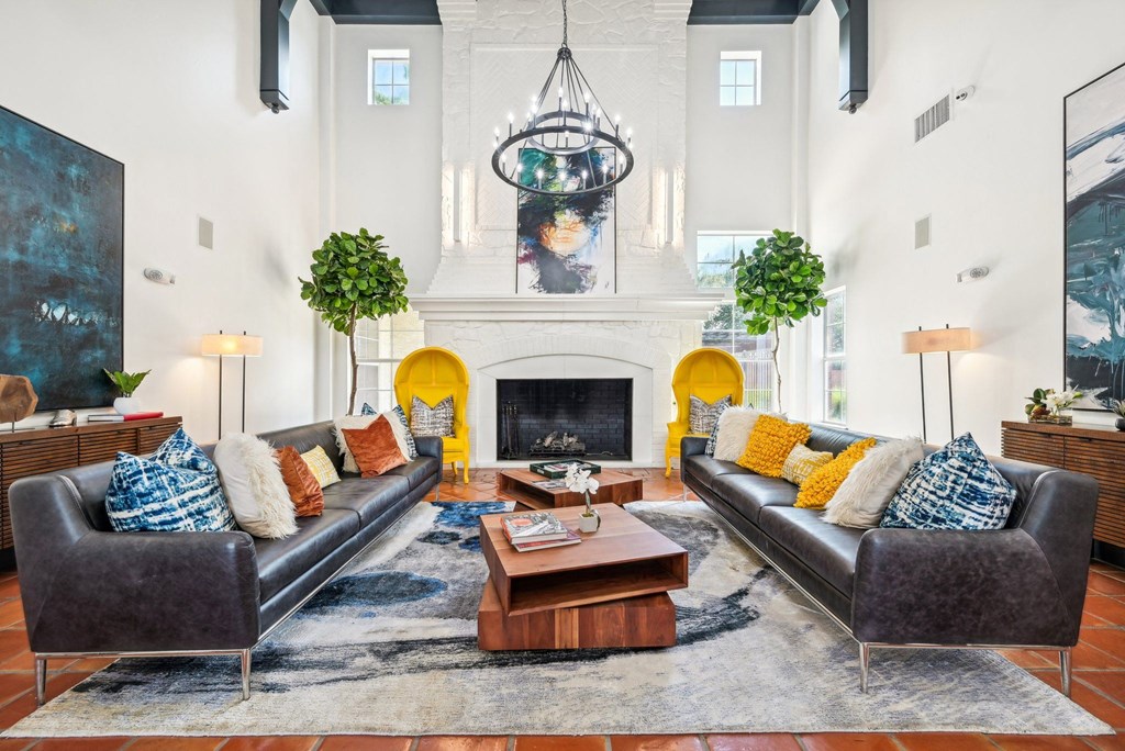 a living room with two leather couches and a fireplace