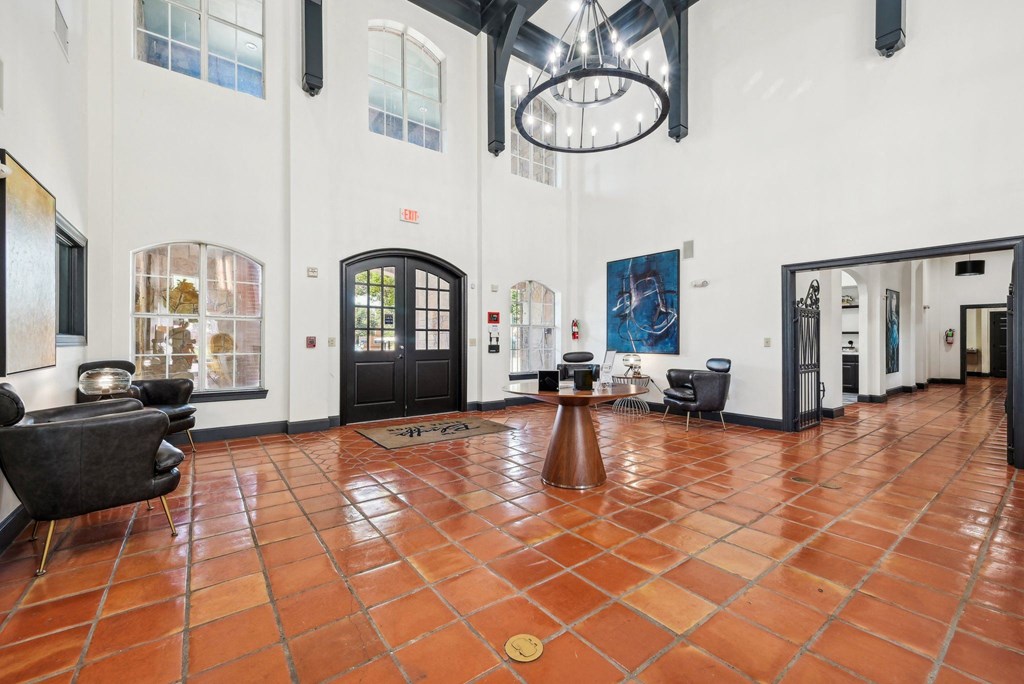 the lobby of a large white building with chairs and a table