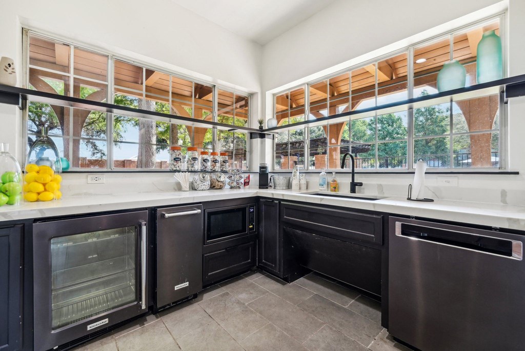 a kitchen with black cabinets and a large window