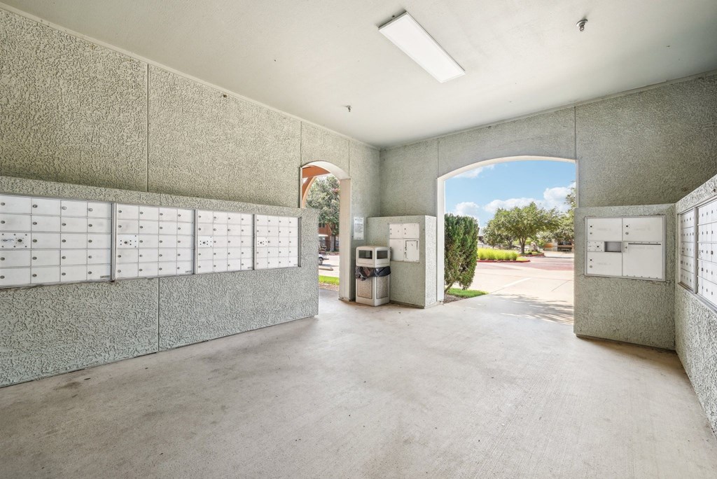 a large room with lockers and a door to a parking lot