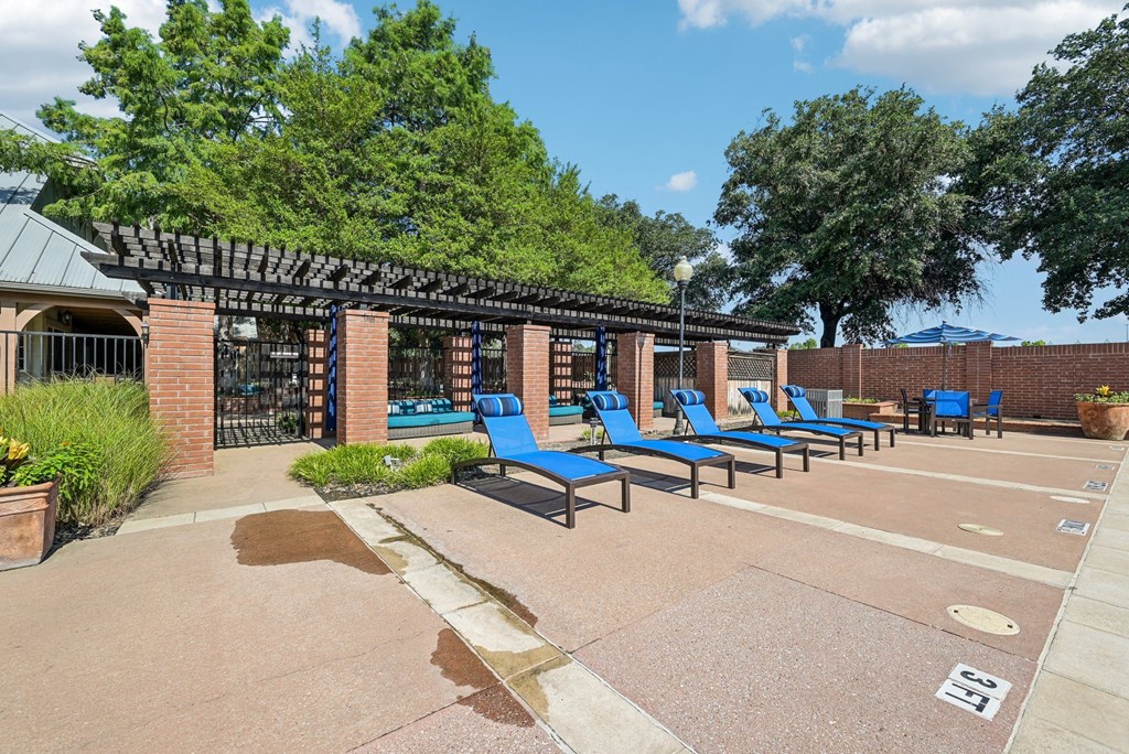 a group of blue lounge chairs in front of a building