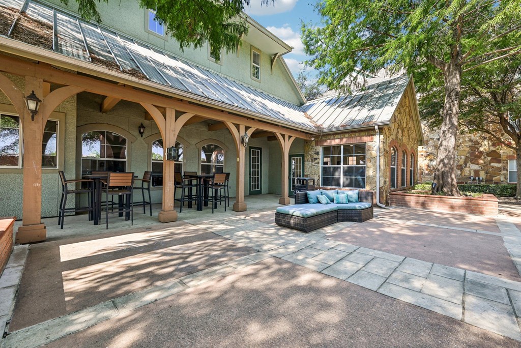 a patio with a couch in front of a house