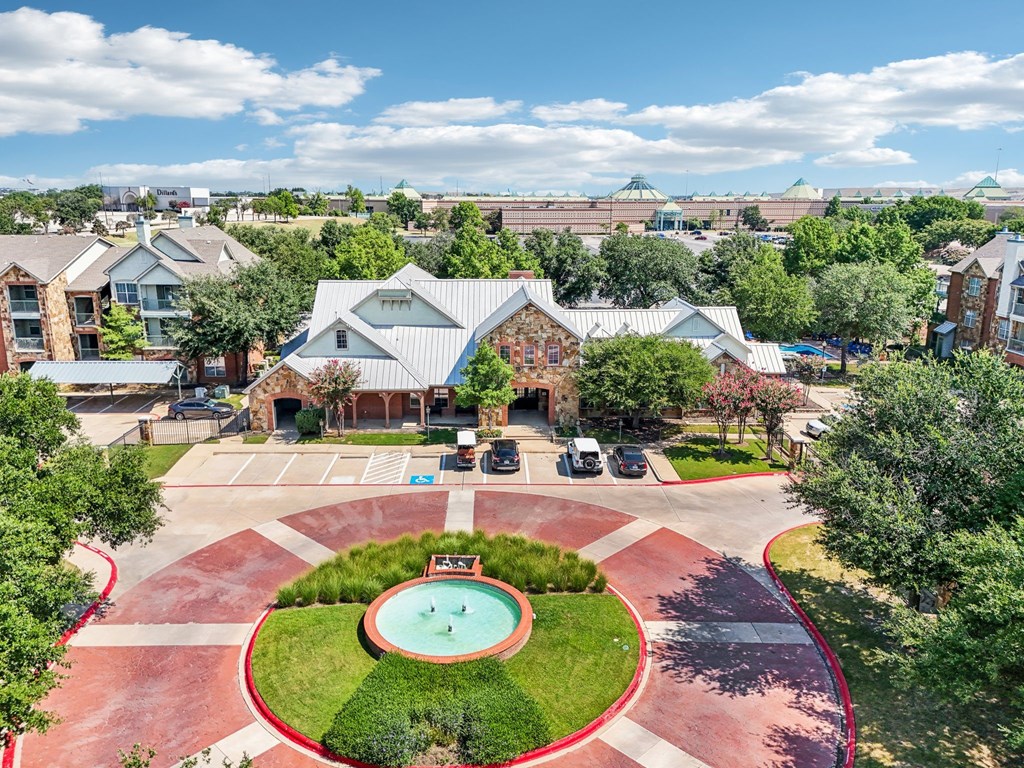 an aerial view of a courtyard with a pool and a building with trees