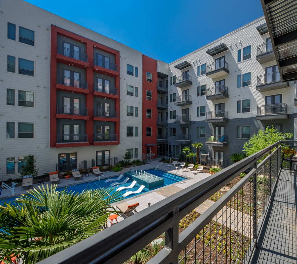 a view of a pool from a balcony of an apartment building