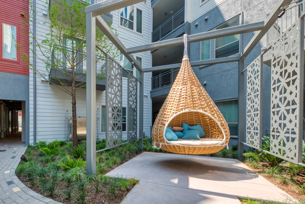 a hanging hammock in the courtyard of an apartment building