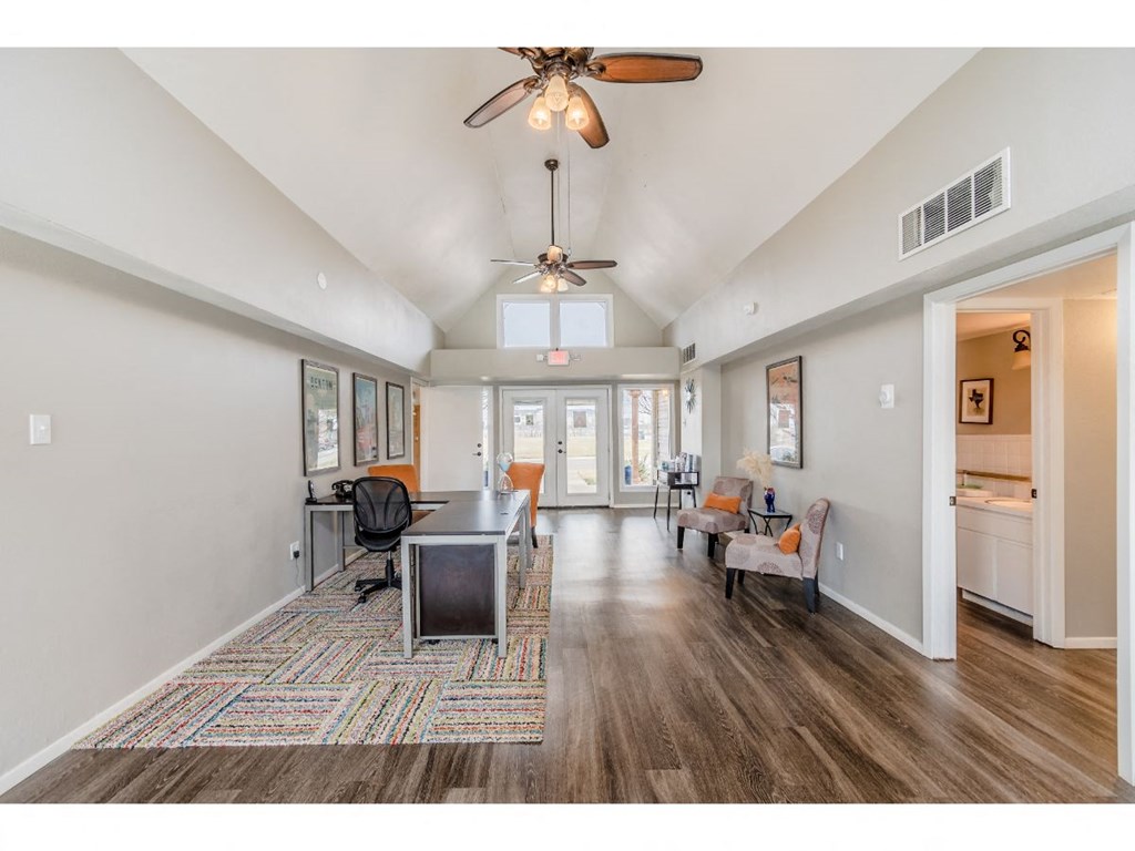 a spacious living room with a ceiling fan and a dining table