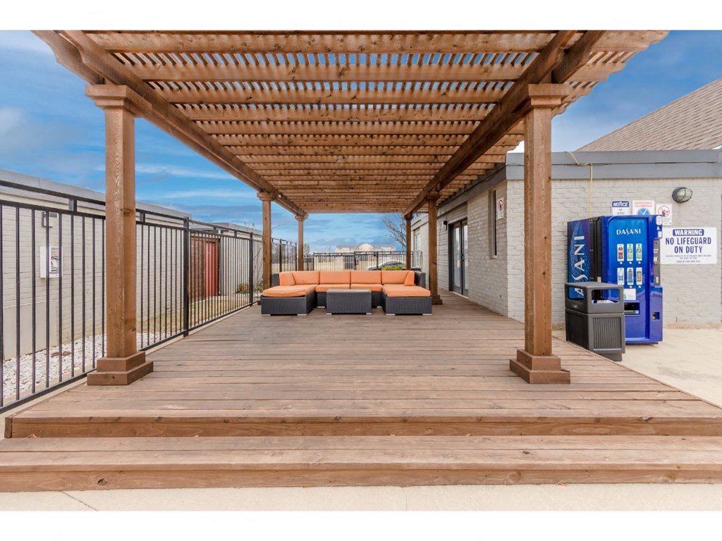 a covered deck with couches and a vending machine