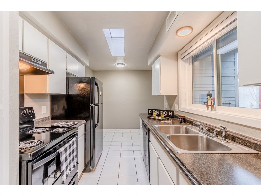 a kitchen with a sink and a stove and a window
