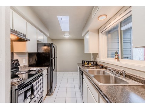 a kitchen with a sink and a stove and a window