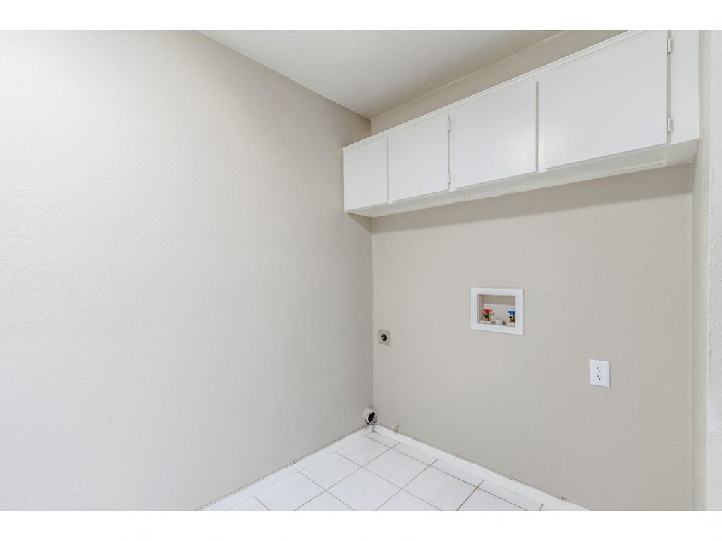 an empty room with white walls and a white floor and white cabinets