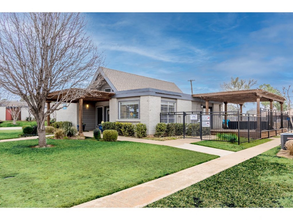 the front of a house with a yard and a gazebo