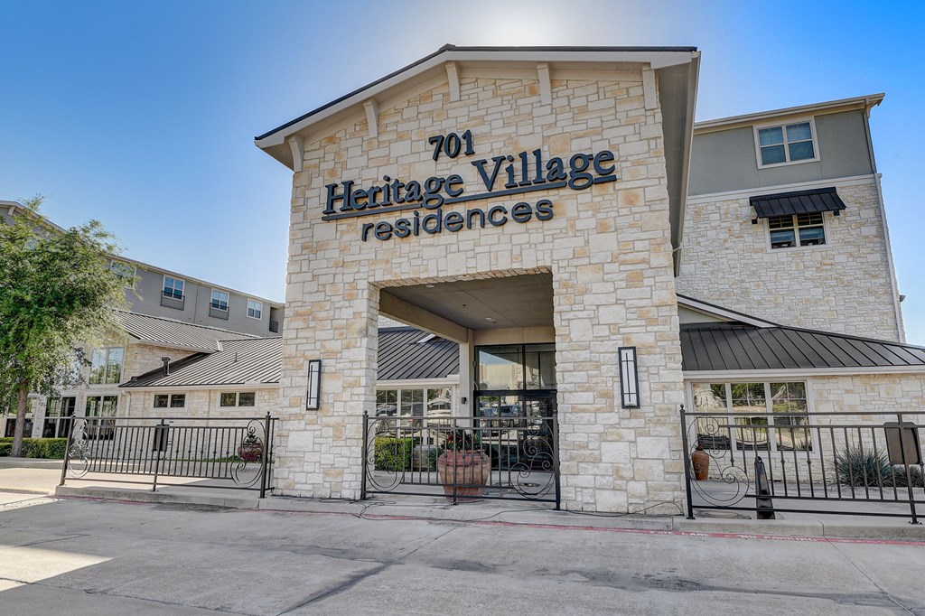 the facade of heritage village residences with a gate