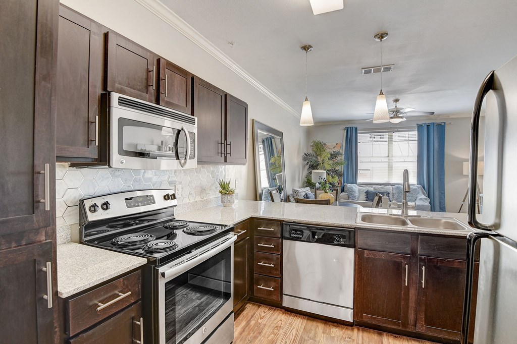 an updated kitchen with stainless steel appliances and wooden cabinets