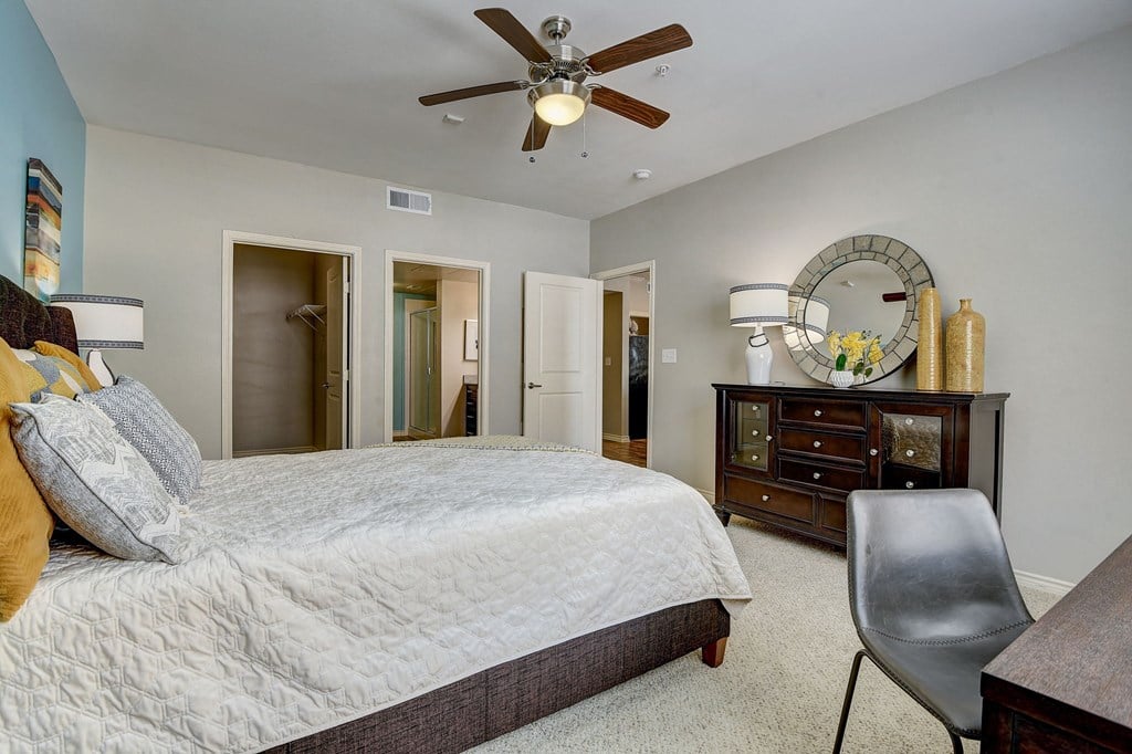a bedroom with a large bed and a ceiling fan